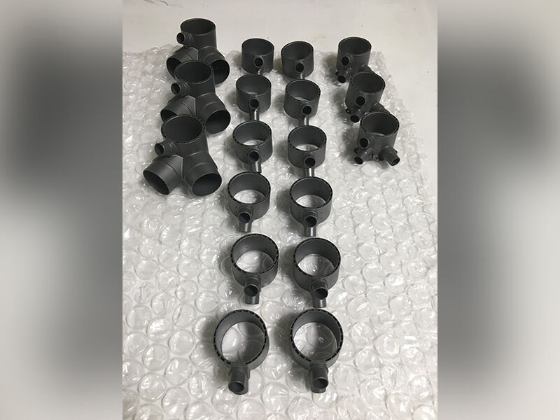 Image shows 3D printed gussets in a dark grey color lined up on a white surface with plastic bubble wrap protecting them from the surface of the table.